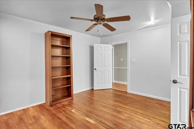 a view of empty room with wooden floor and window