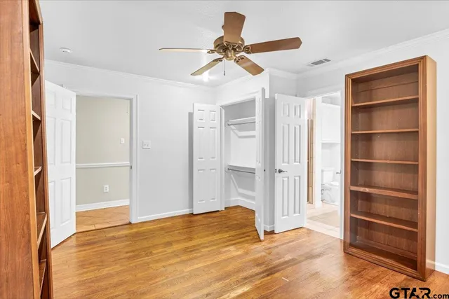 a view of empty room with cabinet and ceiling fan