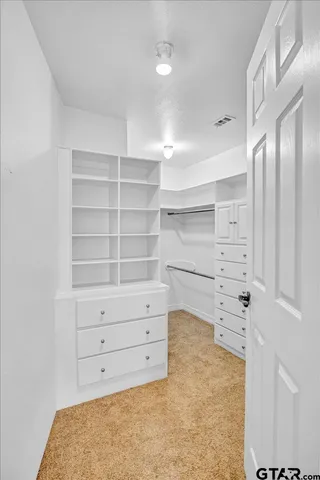 a view of walk in closet with clothes