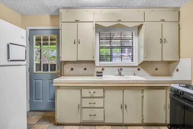 a kitchen with stainless steel appliances a sink stove and window