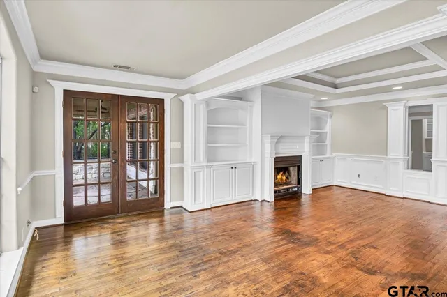 wooden floor fireplace and windows in an empty room