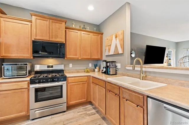 a kitchen with stainless steel appliances granite countertop a refrigerator stove microwave and sink