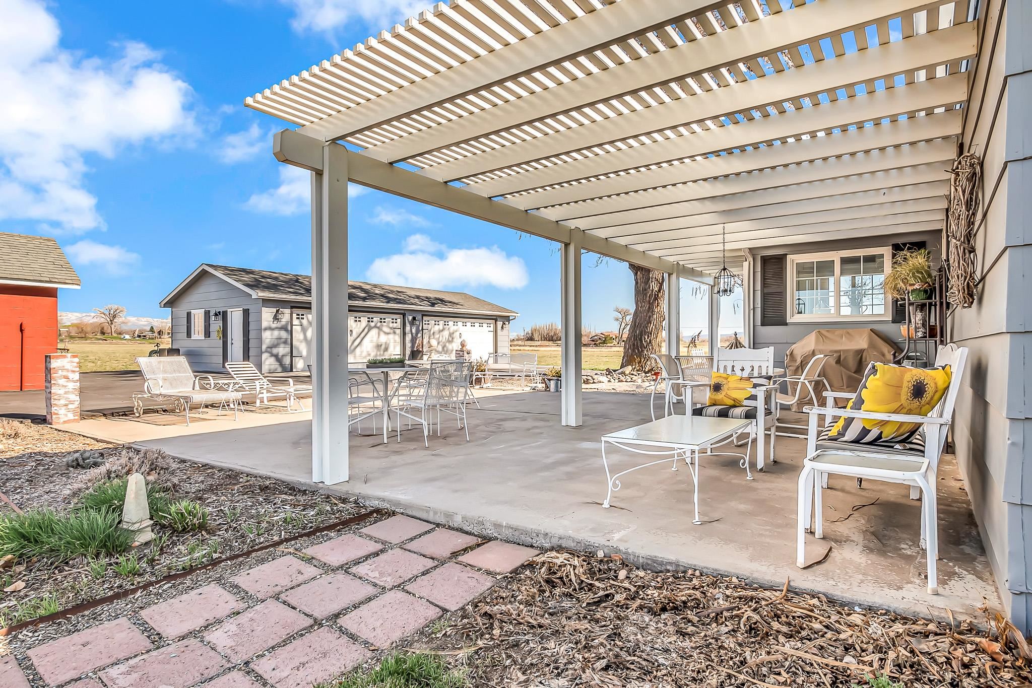 912 24 Road Grand Junction, CO 81505 - Photo 30 of 42 a view of a patio with dining table and chairs with wooden floor