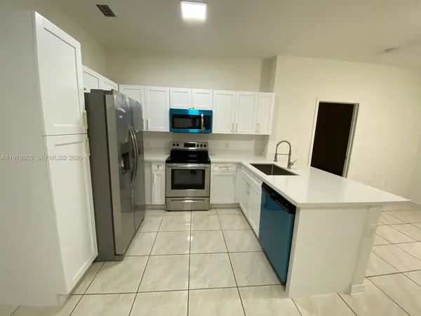 a kitchen with stainless steel appliances a refrigerator stove microwave and sink