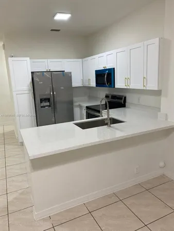 a kitchen with stainless steel appliances a refrigerator sink and microwave