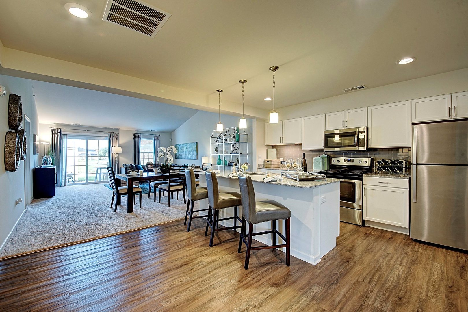 4222 Pond Willow Road Naperville, IL 60564 - Photo 2 of 7 a kitchen with stainless steel appliances granite countertop a refrigerator a stove top oven a dining table and chairs with wooden floor