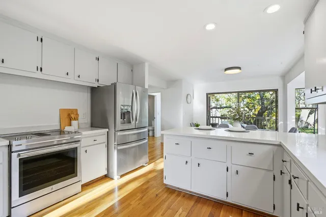 a kitchen with white cabinets white stainless steel appliances and sink
