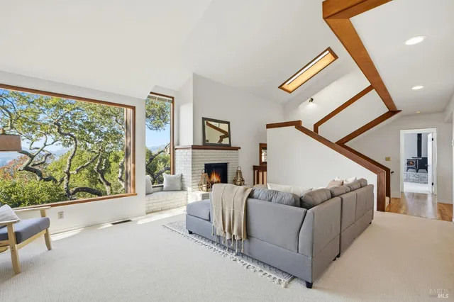 a living room with furniture a fireplace and a large window