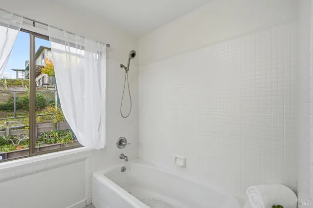 a bathroom with a shower curtain and a large window