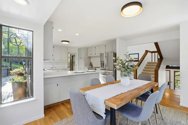 a dining room with wooden floor and a chandelier