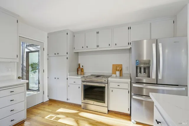 a kitchen with white cabinets and stainless steel appliances
