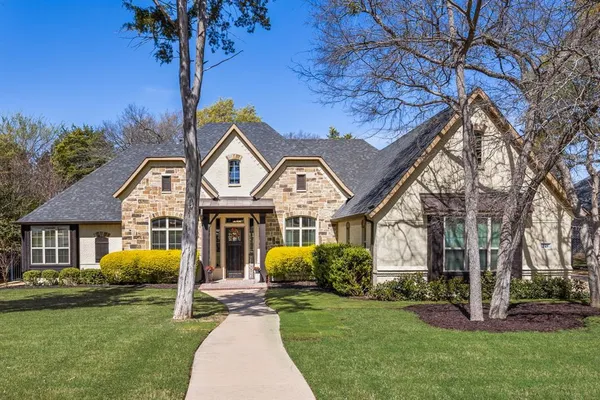 a front view of a house with garden and trees
