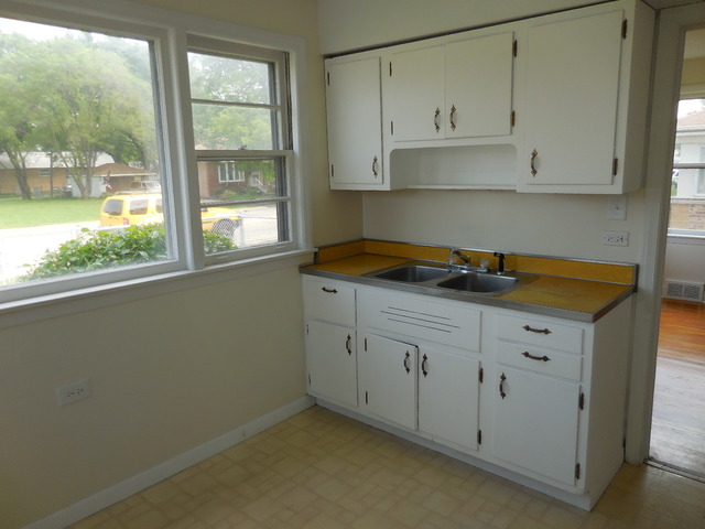 4723 Butterfield Road Hillside, IL 60162 - Photo 4 of 10 a kitchen with granite countertop white cabinets and a window