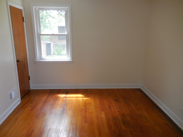 4723 Butterfield Road Hillside, IL 60162 - Photo 6 of 10 an empty room with wooden floor and windows