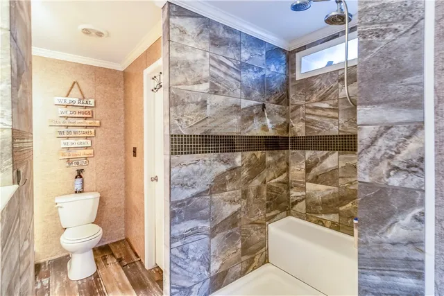 a bathroom with a toilet and a shower