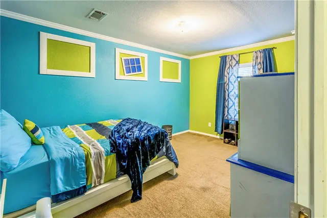 a bedroom with a bed and painting on the wall