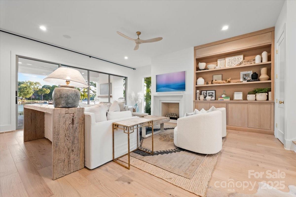 21520 Rio Oro Drive Cornelius, NC 28031 - Photo 6 of 43 a living room with furniture a fireplace and a flat screen tv