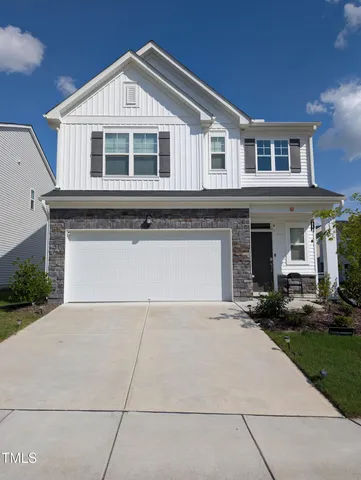 a front view of a house with a yard and garage