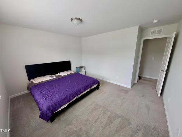 a bedroom with a bed and a night stand