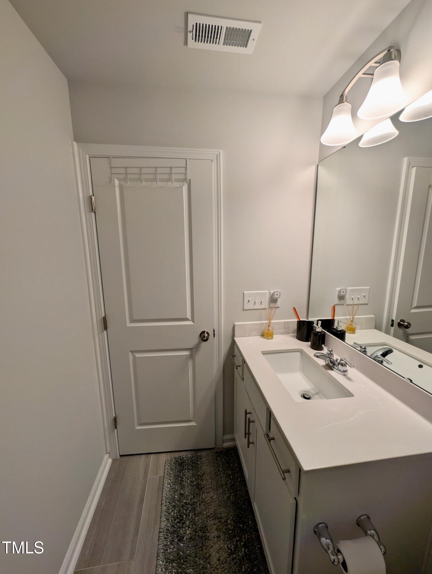 3300 Star Gazing Lane Durham, NC 27703 - Photo 16 of 31 a bathroom with a sink a vanity and a mirror