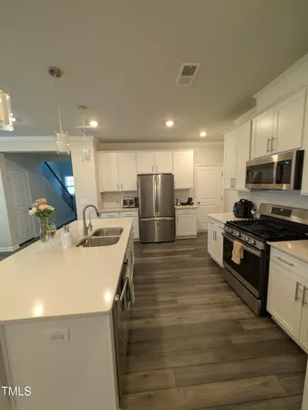 a kitchen with stainless steel appliances granite countertop a sink stove and refrigerator