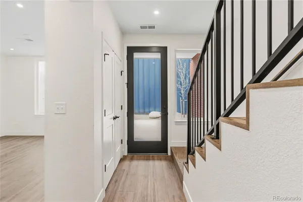 a view of a hallway with wooden floor and staircase