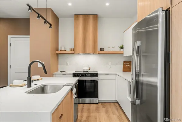 a kitchen with a refrigerator sink and white cabinets