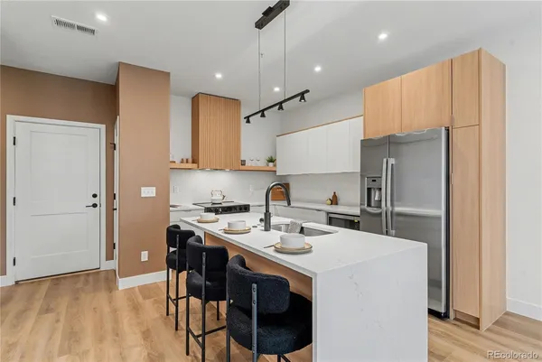 a kitchen with a sink a stove a refrigerator and cabinets