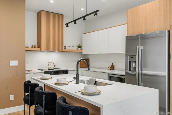 a kitchen with stainless steel appliances granite countertop a sink stove and refrigerator