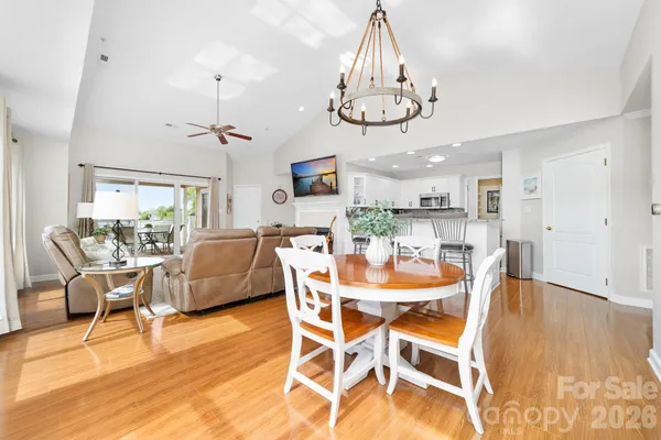 a view of a dining room with furniture a chandelier and wooden floor