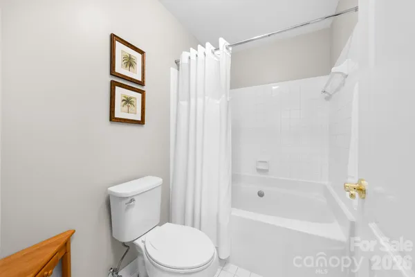 a white toilet sitting next to a bath tub