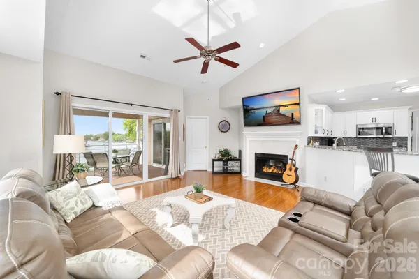 a living room with furniture a fireplace and a large window