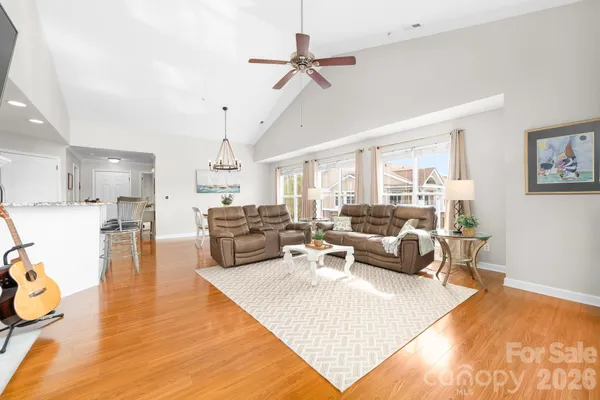 a living room with furniture kitchen view and a chandelier