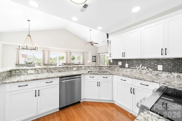 a kitchen with granite countertop white cabinets and white appliances
