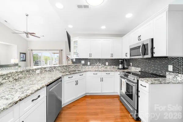a kitchen with stainless steel appliances granite countertop a sink and stove top oven