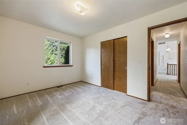 an empty room with windows and closet