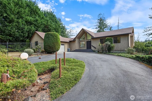 a view of a house with a small yard and a large tree