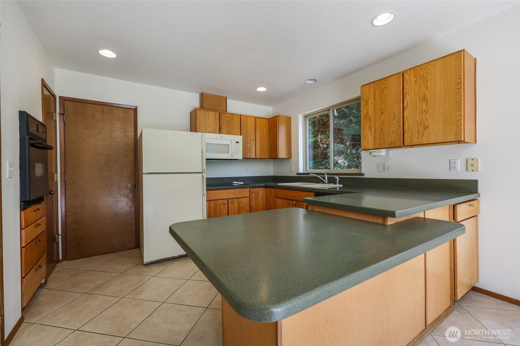 7922 Ellison Loop Northwest Olympia, WA 98502 - Photo 10 of 40 a kitchen with stainless steel appliances granite countertop a sink refrigerator and microwave