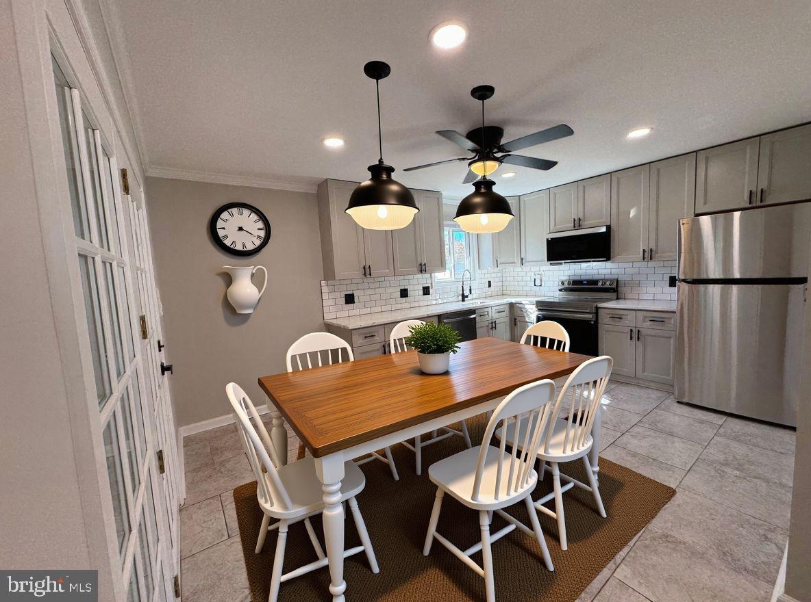 602 Eliot Road Pasadena, MD 21122 - Photo 6 of 30 a view of a dining room with furniture a kitchen and chandelier