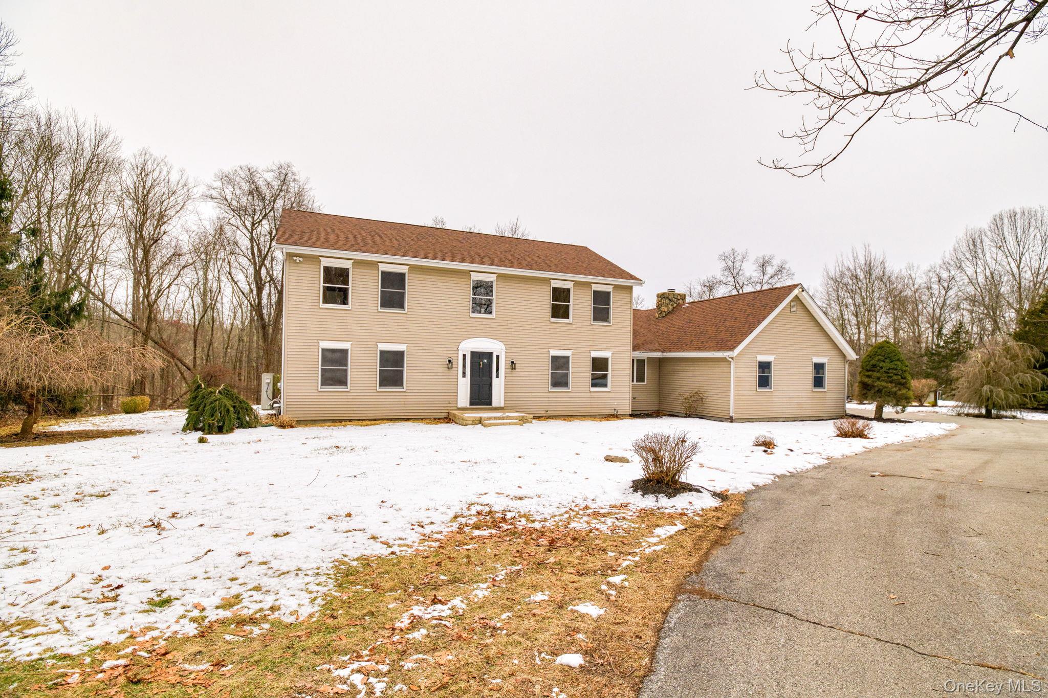 a front view of a house with a yard covered in snow