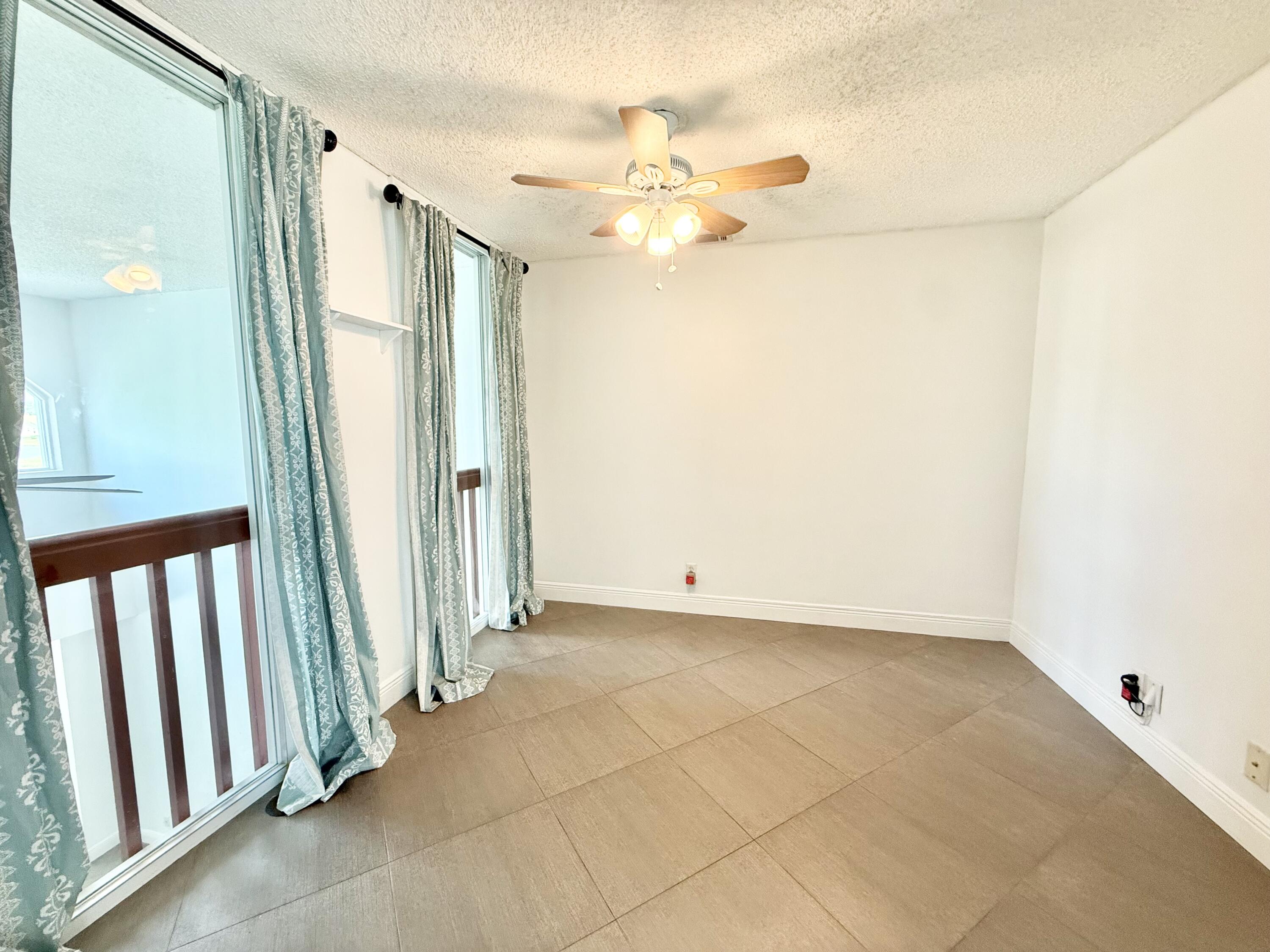 9190 Boca Gardens Parkway, Unit B Boca Raton, FL 33496 - Photo 23 of 35 a view of a hallway with a chandelier fan and windows