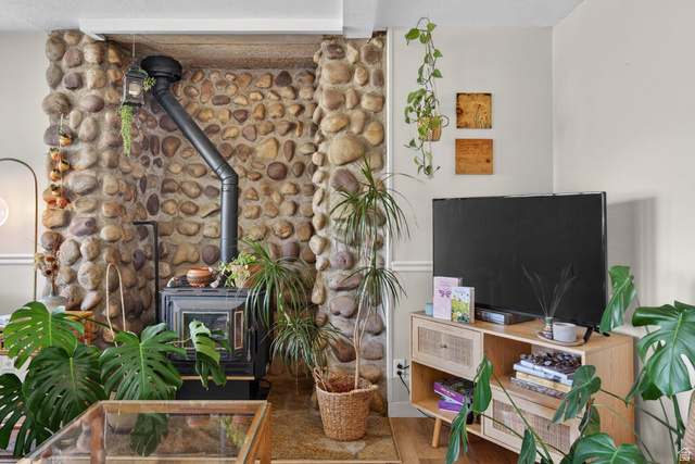 380 Luzern Road Midway, UT 84049 - Photo 43 of 74 River rock accent wall featuring a black wood-burning stove with a matching stovepipe