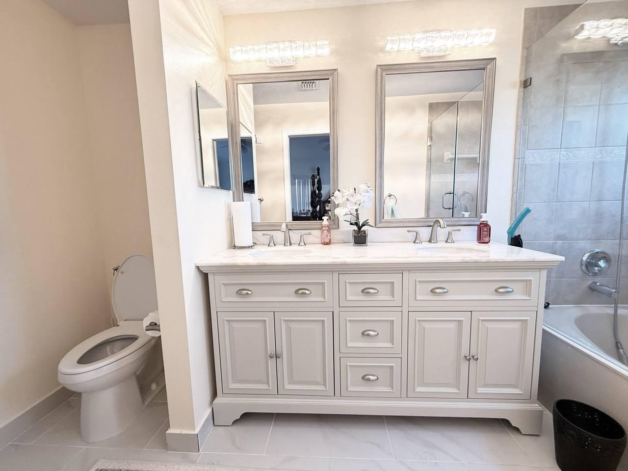 1067 Big Torch Street Riviera Beach, FL 33407 - Photo 12 of 23 a bathroom with a double vanity sink a toilet and a mirror