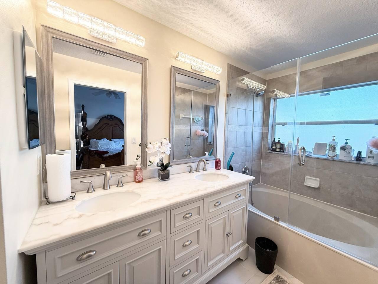 1067 Big Torch Street Riviera Beach, FL 33407 - Photo 13 of 23 a bathroom with a granite countertop sink mirror and bathtub