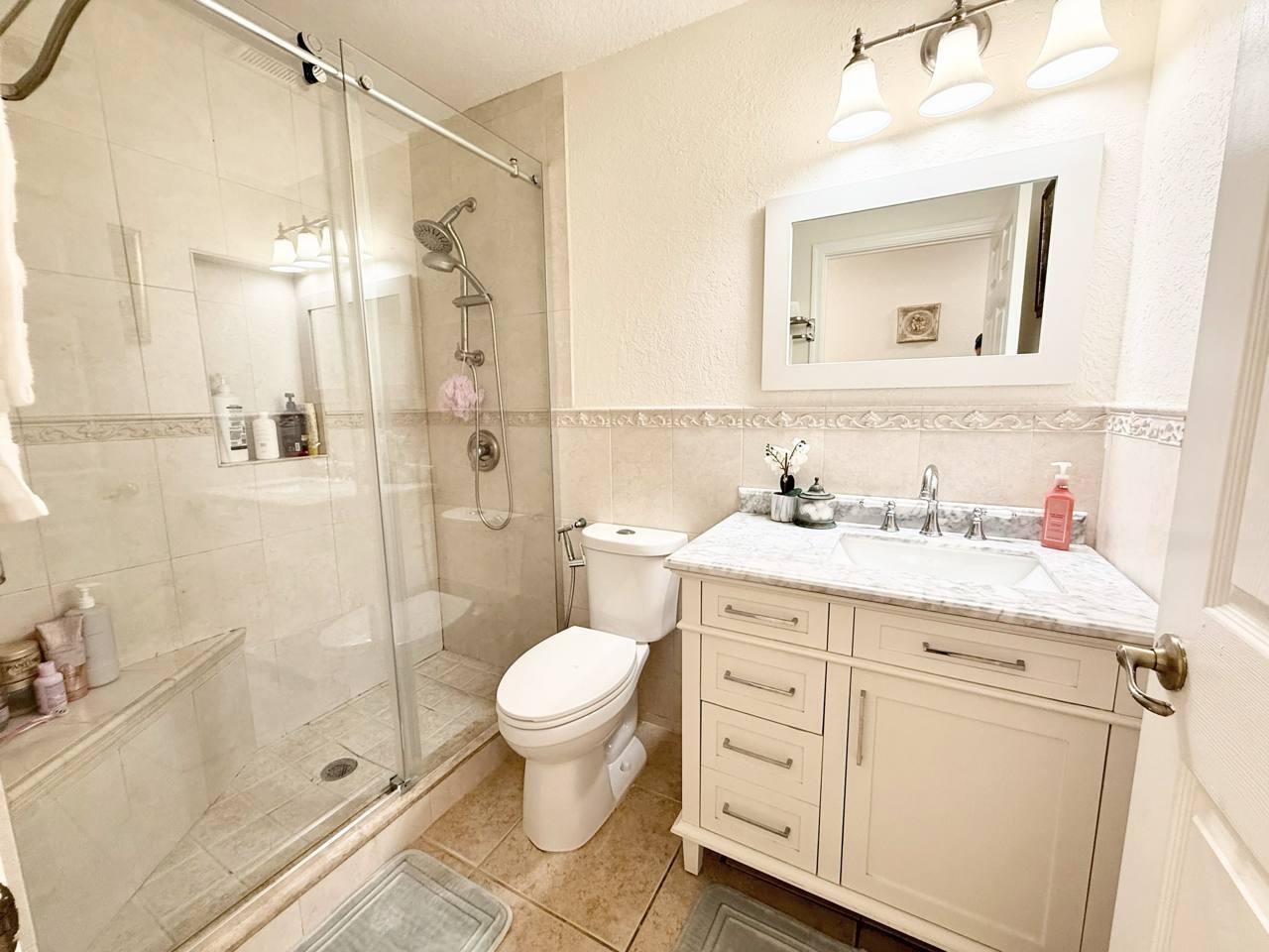 1067 Big Torch Street Riviera Beach, FL 33407 - Photo 15 of 23 a bathroom with a granite countertop sink a toilet and shower