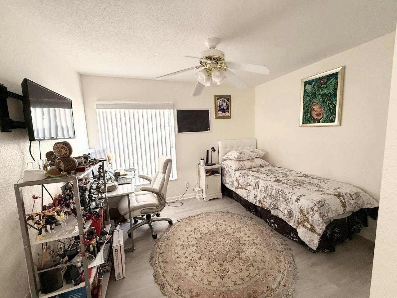 1067 Big Torch Street Riviera Beach, FL 33407 - Photo 16 of 23 a bedroom with a bed and a chandelier