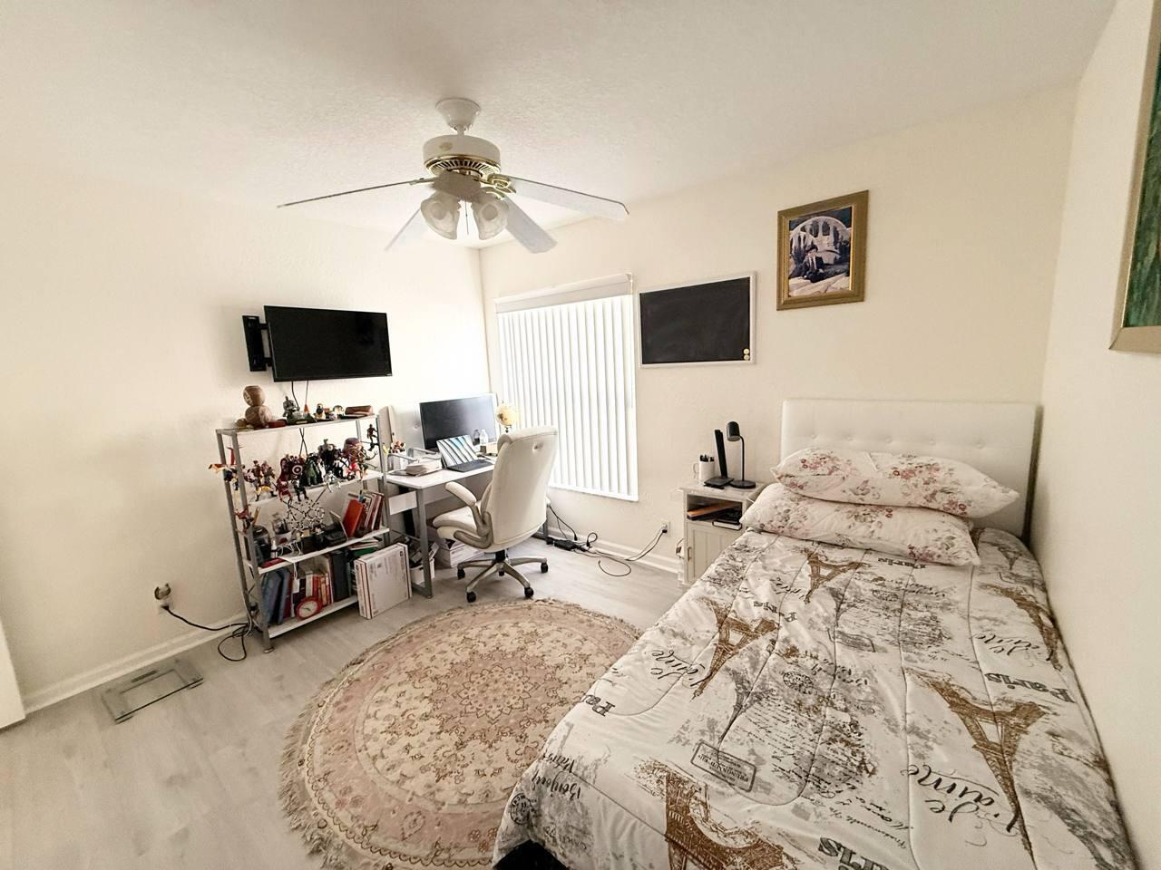 1067 Big Torch Street Riviera Beach, FL 33407 - Photo 17 of 23 a bedroom with a bed and a flat screen tv
