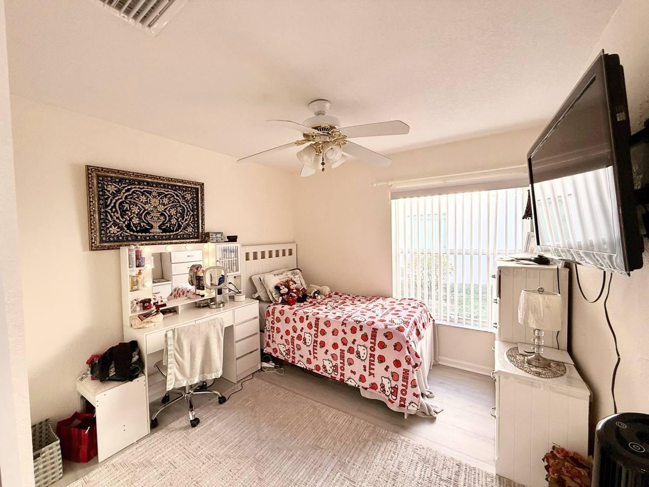 1067 Big Torch Street Riviera Beach, FL 33407 - Photo 18 of 23 a bedroom with a bed and a chandelier