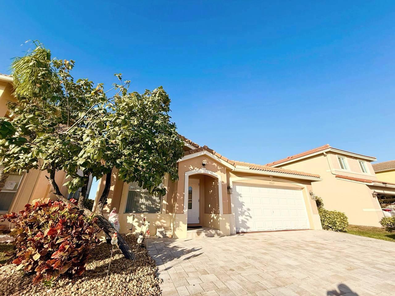 1067 Big Torch Street Riviera Beach, FL 33407 - Photo 2 of 23 a view of a house with a yard