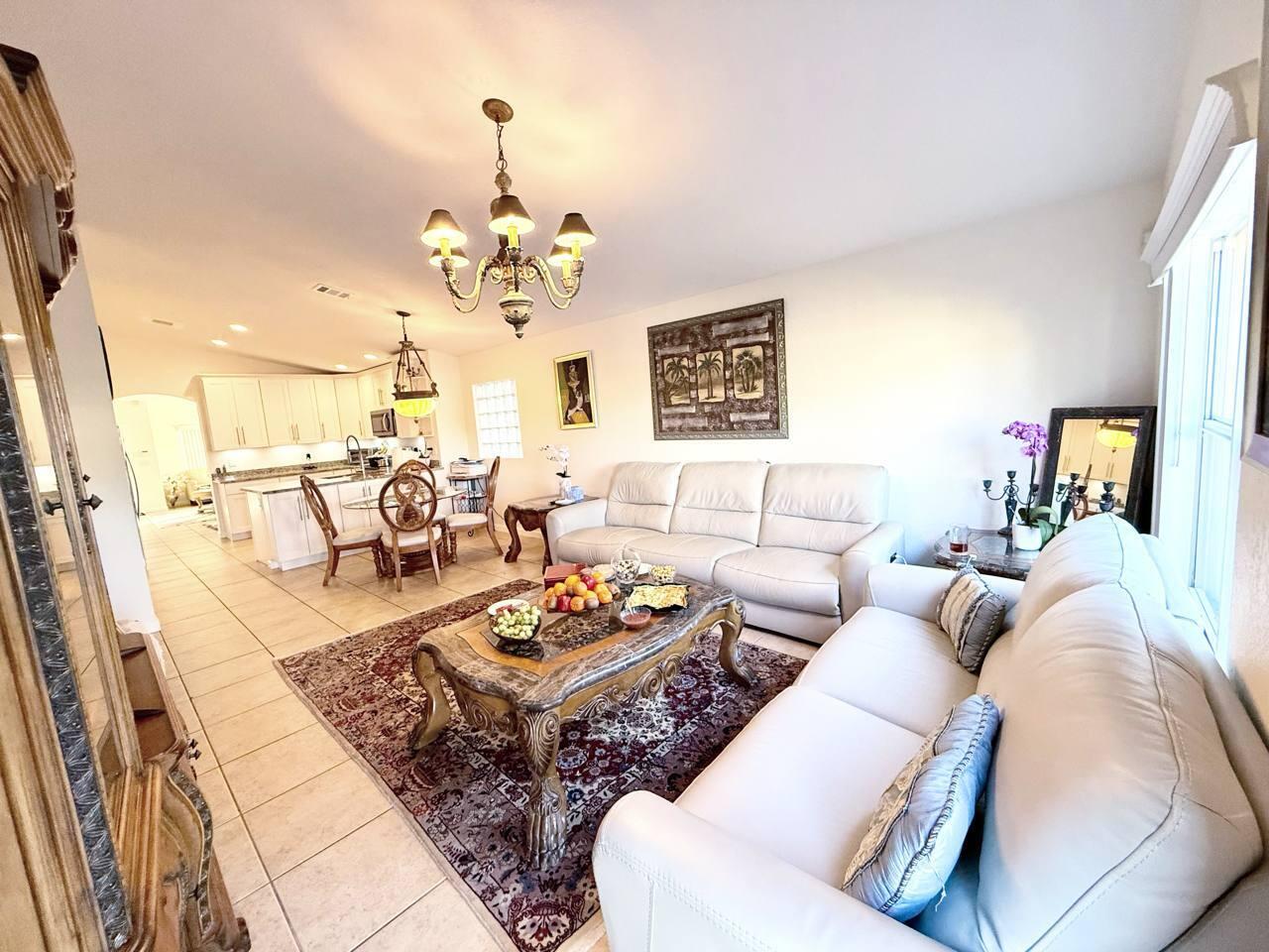 1067 Big Torch Street Riviera Beach, FL 33407 - Photo 10 of 23 a living room with furniture kitchen view and a chandelier